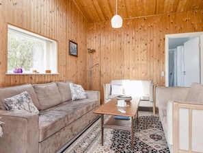 A cozy room with a wooden ceiling, a sofa, a coffee table, and a patterned rug. - Vintage Holiday Home in Struer near Open Field (Struer)