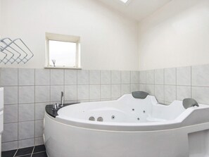 A modern bathroom with a freestanding bathtub, a window, and a towel rack. - Vintage Holiday Home in Struer near Open Field (Struer)