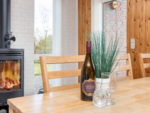 A wooden table with a bottle of wine, a glass, and a potted plant. - Vintage Holiday Home in Struer near Open Field (Struer)