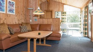 A cozy cabin interior with a wooden interior, a sofa set, a dining table, and a balcony with a view. - 6 Person Holiday Home in Fano (Fano)