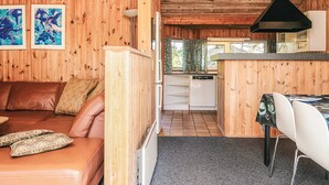 A cozy cabin interior with a wooden interior, a living area with a leather couch, a dining table with chairs, and a kitchen area with a dishwasher. - 6 Person Holiday Home in Fano (Fano)