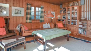A cozy cabin interior with a wooden interior, a sofa, a dining table, and a bookshelf. - 4 Person Holiday Home in Bogo By-by Traum (Bogø By)