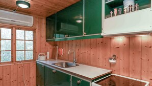A kitchen with wooden walls, a sink, a stove, and cabinets. - 4 Person Holiday Home in Bogo By-by Traum (Bogø By)