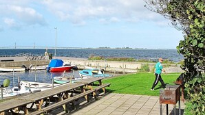 A dock with boats, a grassy area, and a body of water. - 4 Person Holiday Home in Bogo By-by Traum (Bogø By)