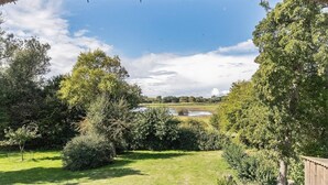 A view from a window overlooking a grassy area with trees and a pond. - 5 Person Holiday Home in Humble (Sydlangeland)