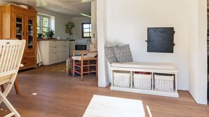 A kitchen with a wooden cabinet, a bench with baskets, and a wall-mounted board. - 5 Person Holiday Home in Humble (Sydlangeland)