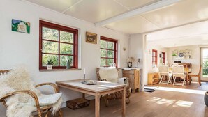 A cozy room with a wooden table, wicker chairs, and a window with a view of greenery. - 5 Person Holiday Home in Humble (Sydlangeland)