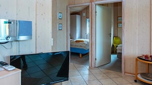 A room with a television, a bed, a desk, and a door leading to another room. - 4 Star Holiday Home in Hemmet (Hemmet)