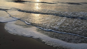 A beach with waves gently lapping onto the shore, reflecting sunlight. - 4 Star Holiday Home in Hemmet (Hemmet)