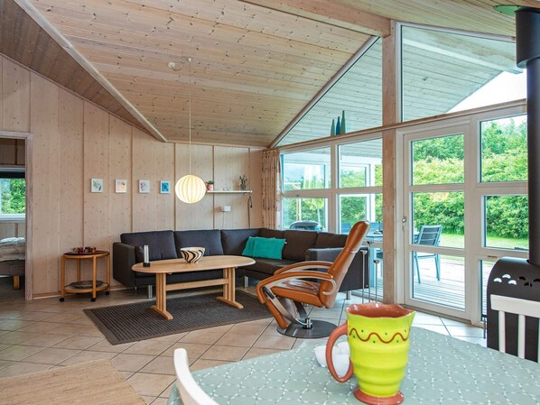 Ein gemütliches Wohnzimmer mit Holzboden, einer Couch, einem Couchtisch und einem Esstisch.