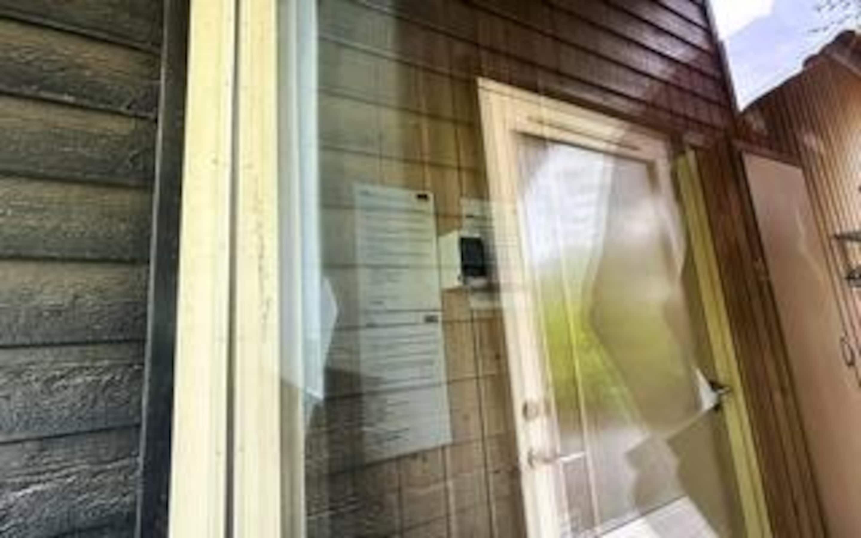 A wooden exterior with a glass door and a small window.