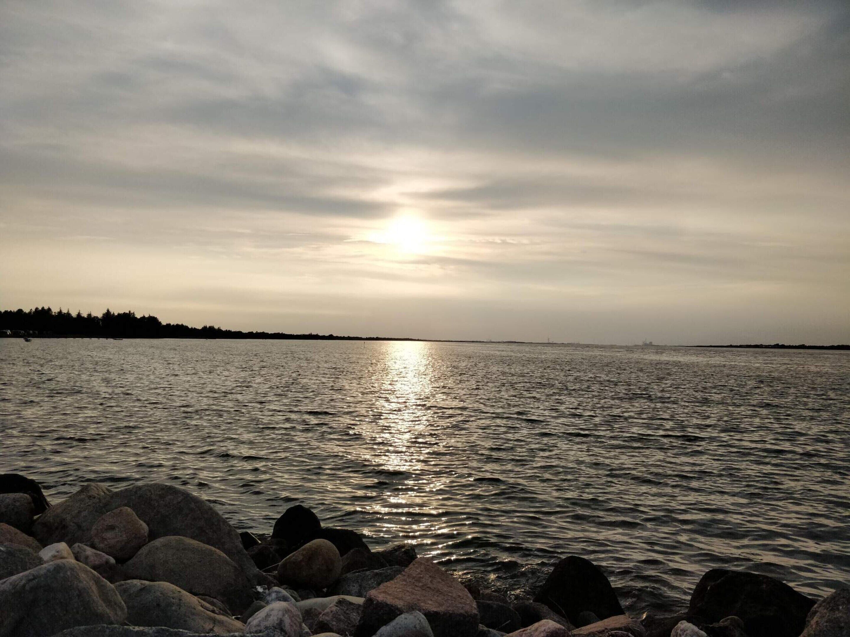 A body of water with a rocky shoreline and a distant horizon.