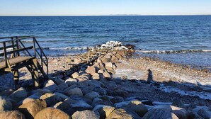 A rocky beach with a wooden jetty extending into the sea. - 4 Person Holiday Home in Hornbaek (Hornbaek)