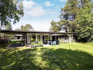 A modern house with a covered patio, a lawn, and a garden. - 4 Person Holiday Home in Hornbaek (Hornbaek)