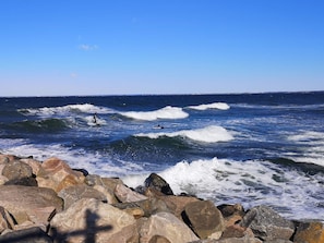A rocky shoreline with waves and surfers. - 4 Person Holiday Home in Hornbaek (Hornbaek)