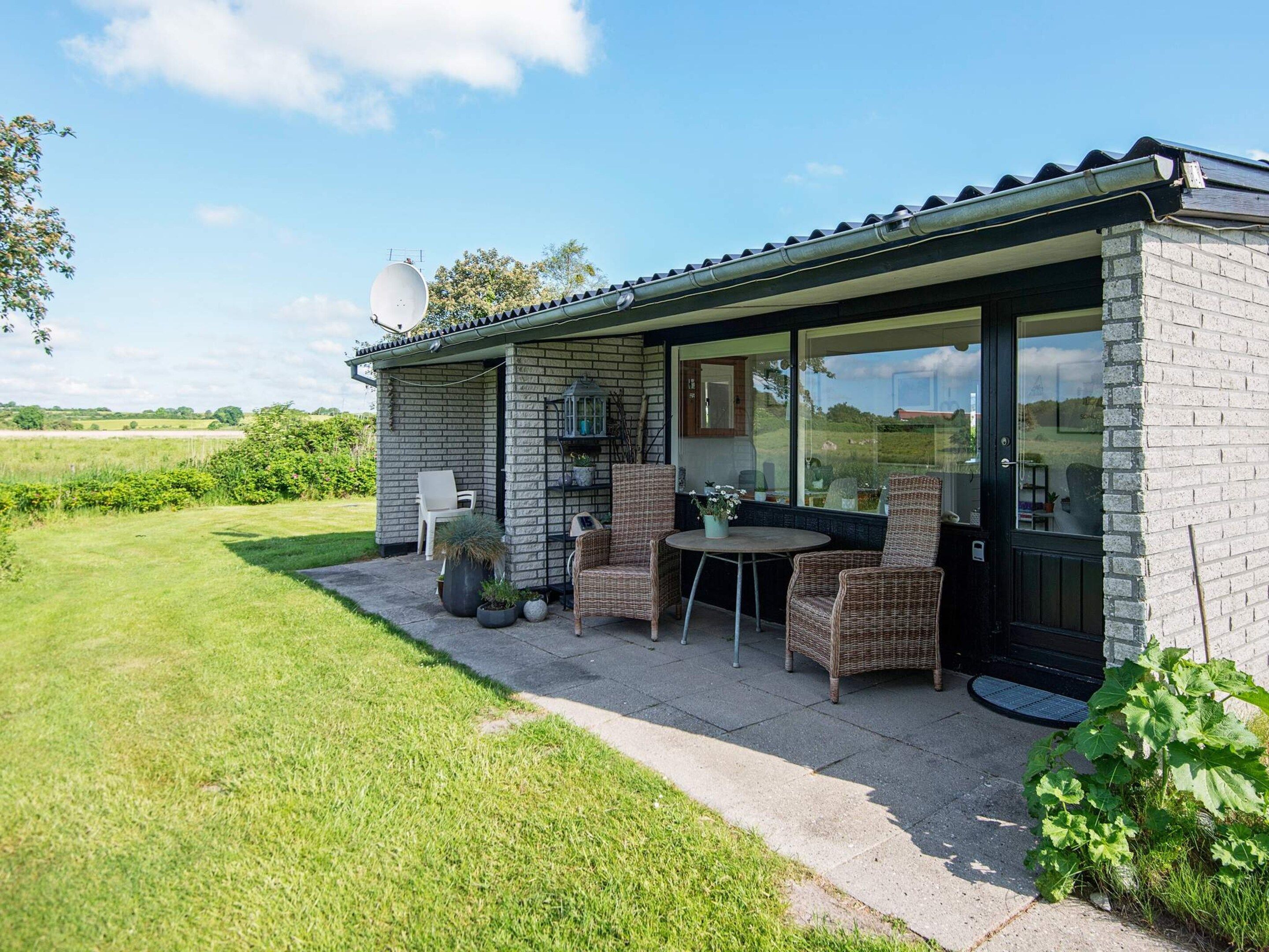 A house with a patio, outdoor seating, and a view of the countryside.