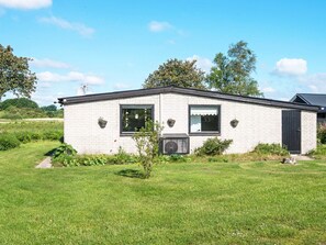 A single-story building with a flat roof, a small front porch, and a black door. - 4 Person Holiday Home in Broager (Broager)