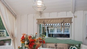 A cozy room with a table set for dining, a window with curtains, and a sign on the window. - 6 Person Holiday Home in Hemmet (Hemmet)