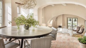 A spacious dining area with a round table, chairs, and a hanging light fixture. - Villa Prenzano, luxury villa with pool, breathtaking views and concierge service (Greve in Chianti)