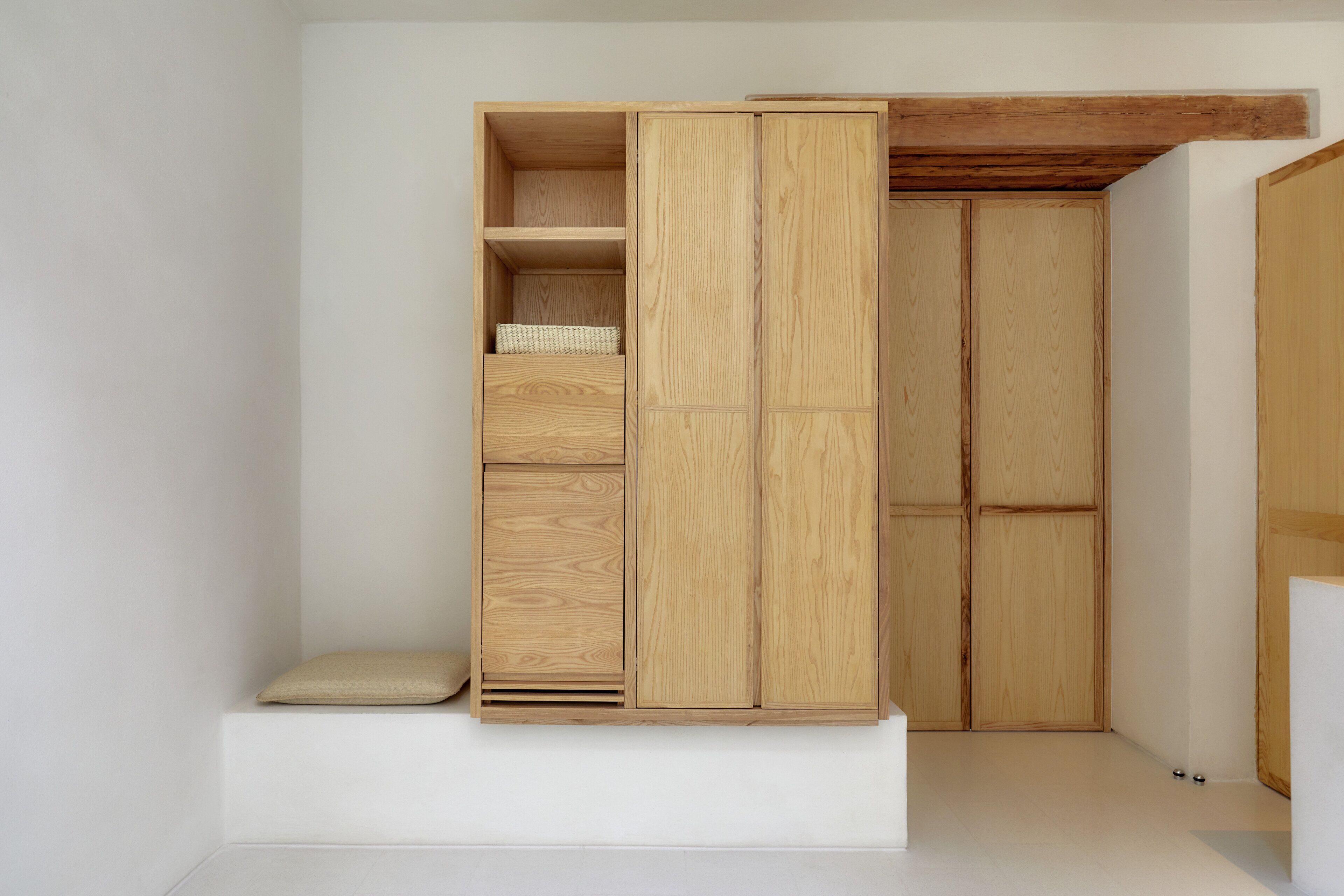 Ein schlichter Holzschrank mit einer Sitzbank, Ablagefläche und einer Aufbewahrungsbox.