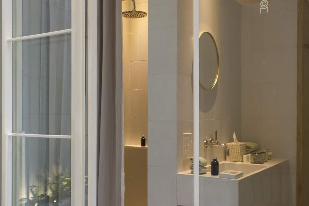 A modern bathroom with a glass door, a shower, and a vanity with a towel rack.