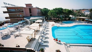 A hotel with a swimming pool, outdoor seating, and a view of the sea. - Hotel Numana Palace (Numana)