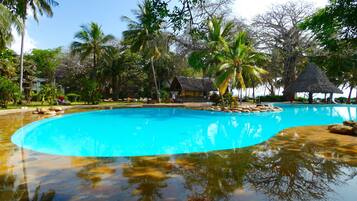 Een buitenzwembad, parasols bij het zwembad en ligstoelen