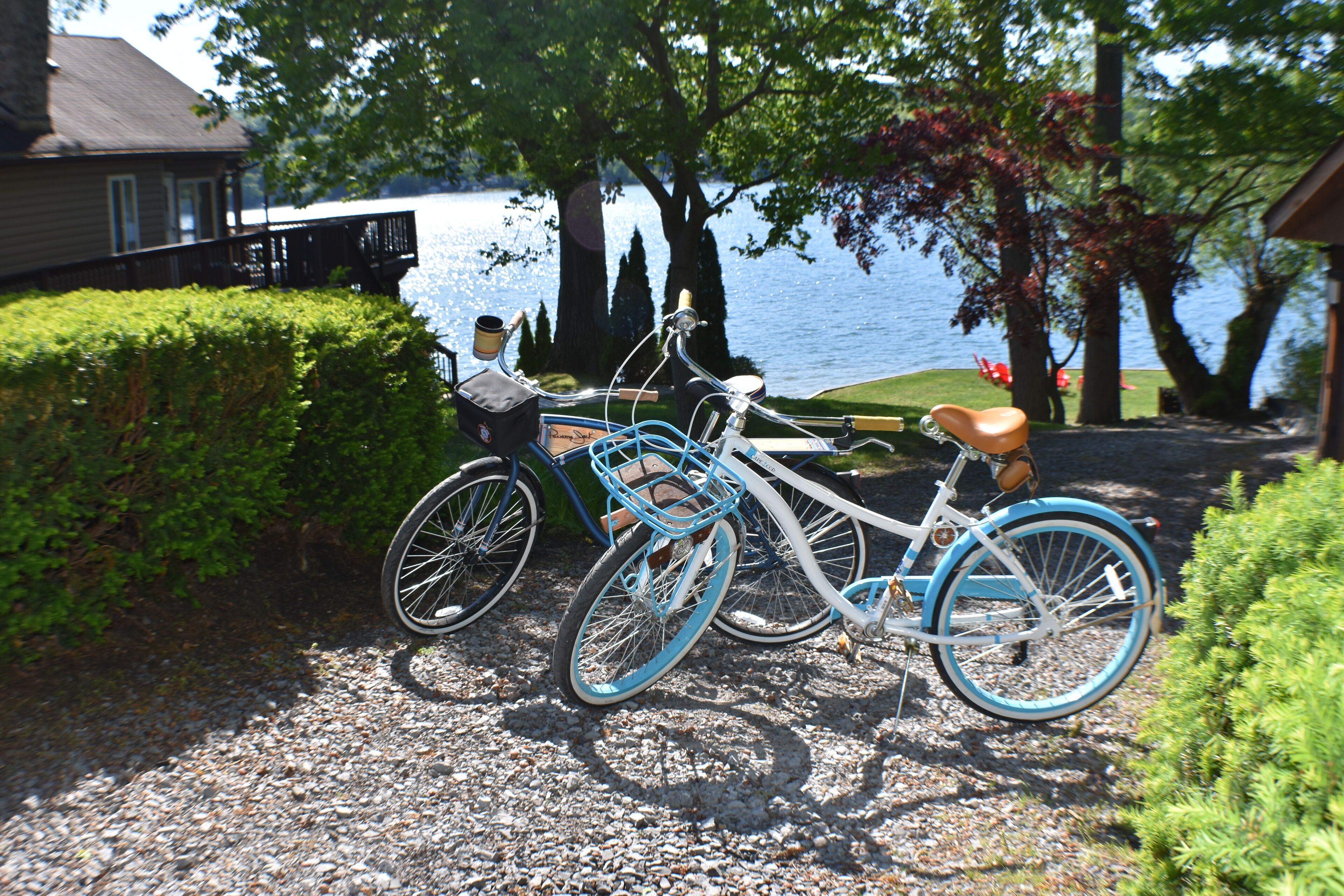 Una bicicleta estacionada en un camino de grava, con un lago y árboles al fondo.