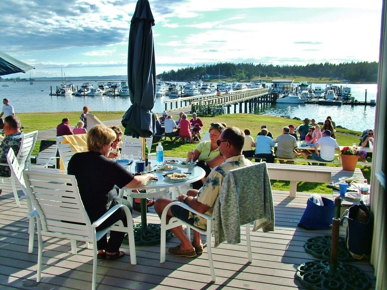 Une terrasse avec coin salon extérieur et vue sur un port de plaisance.
