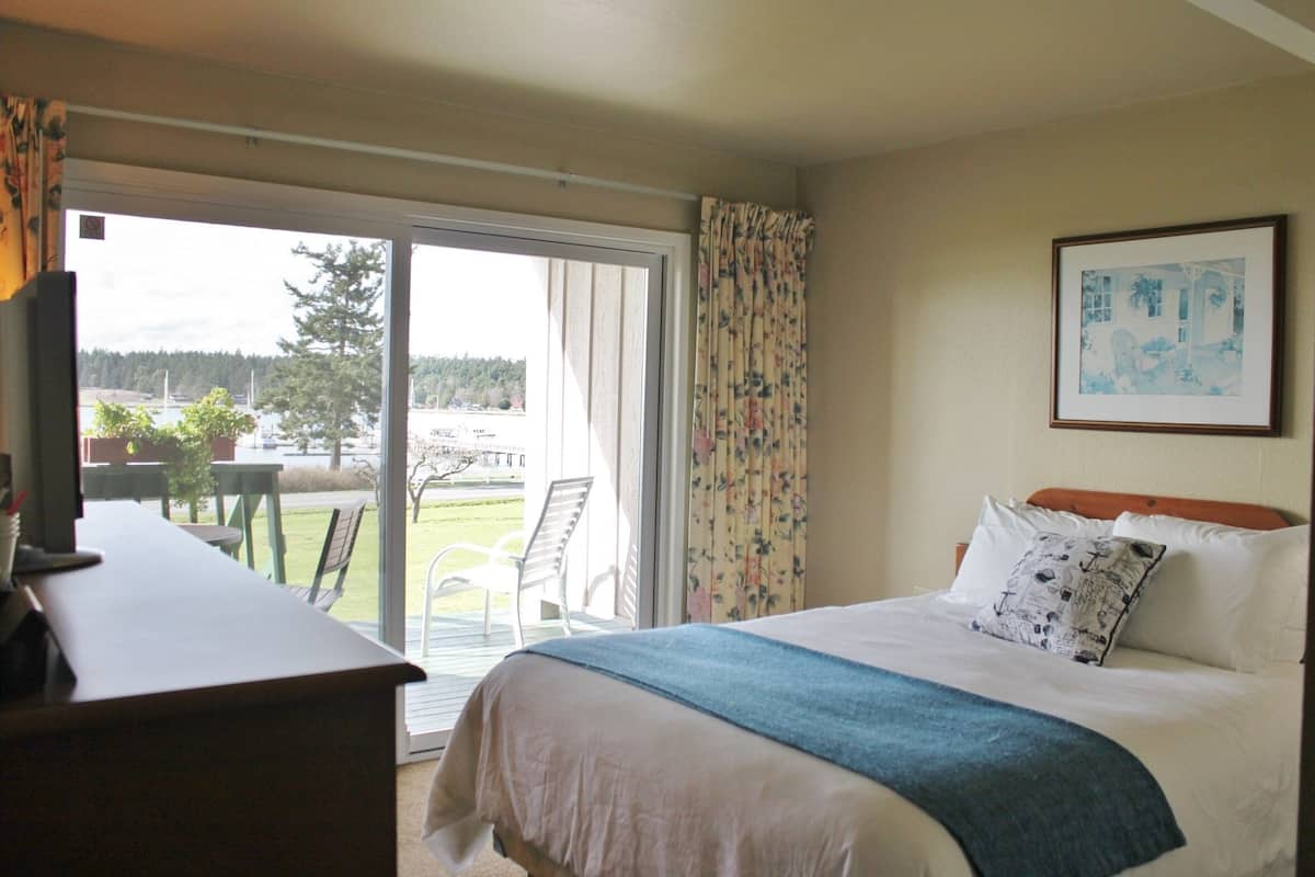 Una habitación de hotel con cama, escritorio y vistas al exterior.