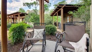 Un espacio de estar al aire libre cubierto con sillas de mimbre y una estructura de pérgola.