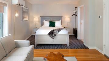 Een hotelkamer met een bed, bedlampen, een plafondventilator, een houten salontafel en een bank.
