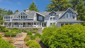 A large, multi-story house with a covered porch and a well-maintained garden. - Ocean House (Newport)