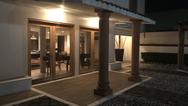 A building with a covered patio area, columns, and a dining area visible through glass doors. - Totalkey (Atizapan de Zaragoza)