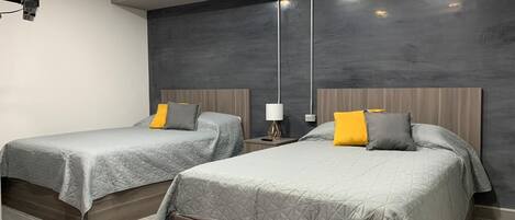 Ett hotellrum med två sängar, modern design och en stor, mörk vägg.