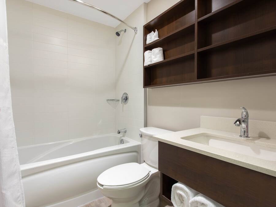 A bathroom with a bathtub, toilet, and a sink.