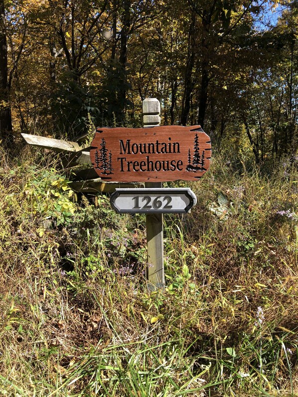 Un panneau en bois portant l’inscription « Mountain Treehouse » et le numéro « 1262 », indiquant un emplacement.
