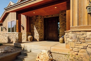 Stunning building with a large wooden door and stone planters.