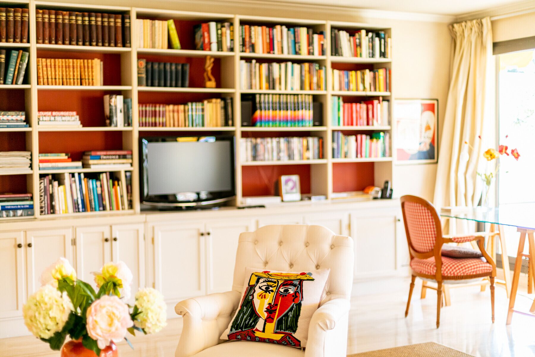 A living room with a sofa, a television, and a bookshelf filled with books.