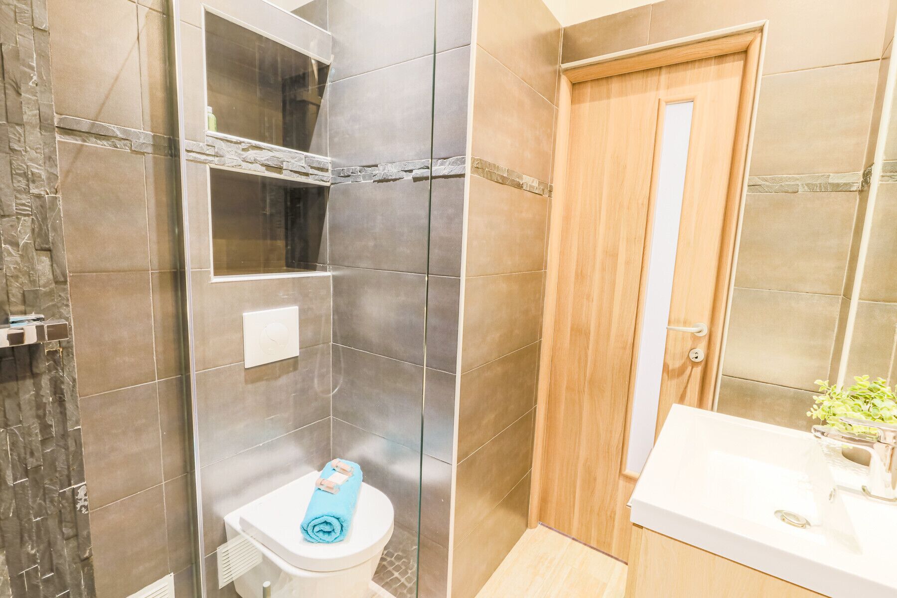 Une salle de bain avec douche, toilettes et lavabo.