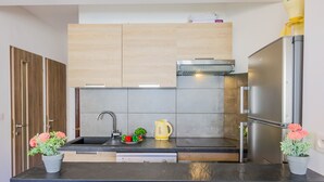 A modern kitchen with a black countertop, stainless steel appliances, and wooden cabinets. - MASSENET PIETONNE  AP4196 by Riviera Holiday Homes (Niza)