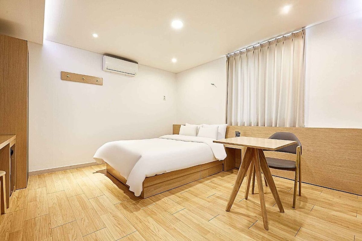 Una camera da letto moderna con un letto, una scrivania e una sedia.