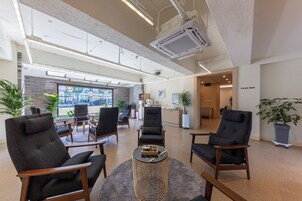 A spacious lobby with modern furniture, a reception desk, and a view of the outside.