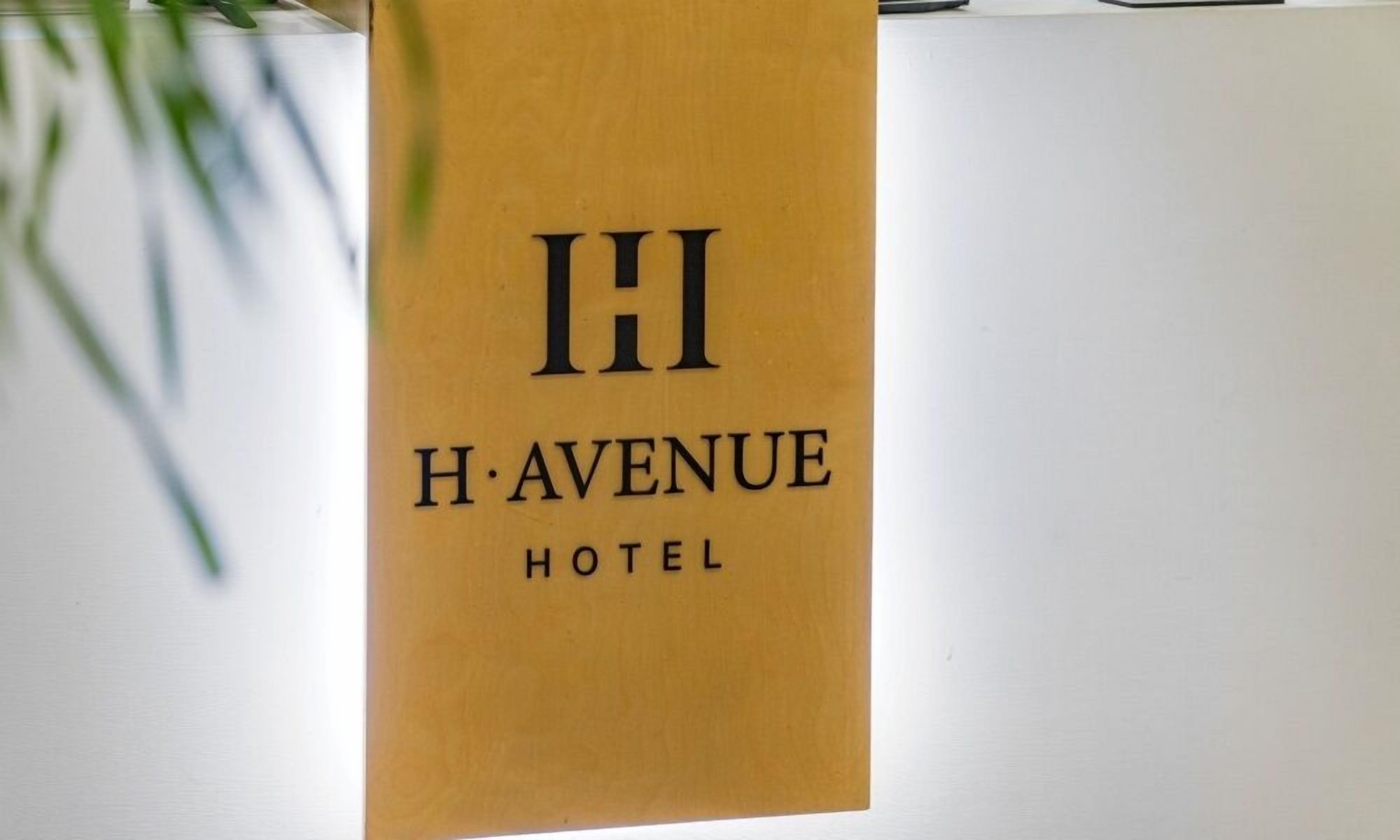 A sign for H. Avenue Hotel with a simple, elegant design.