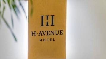 A sign for H. Avenue Hotel with a simple, elegant design.