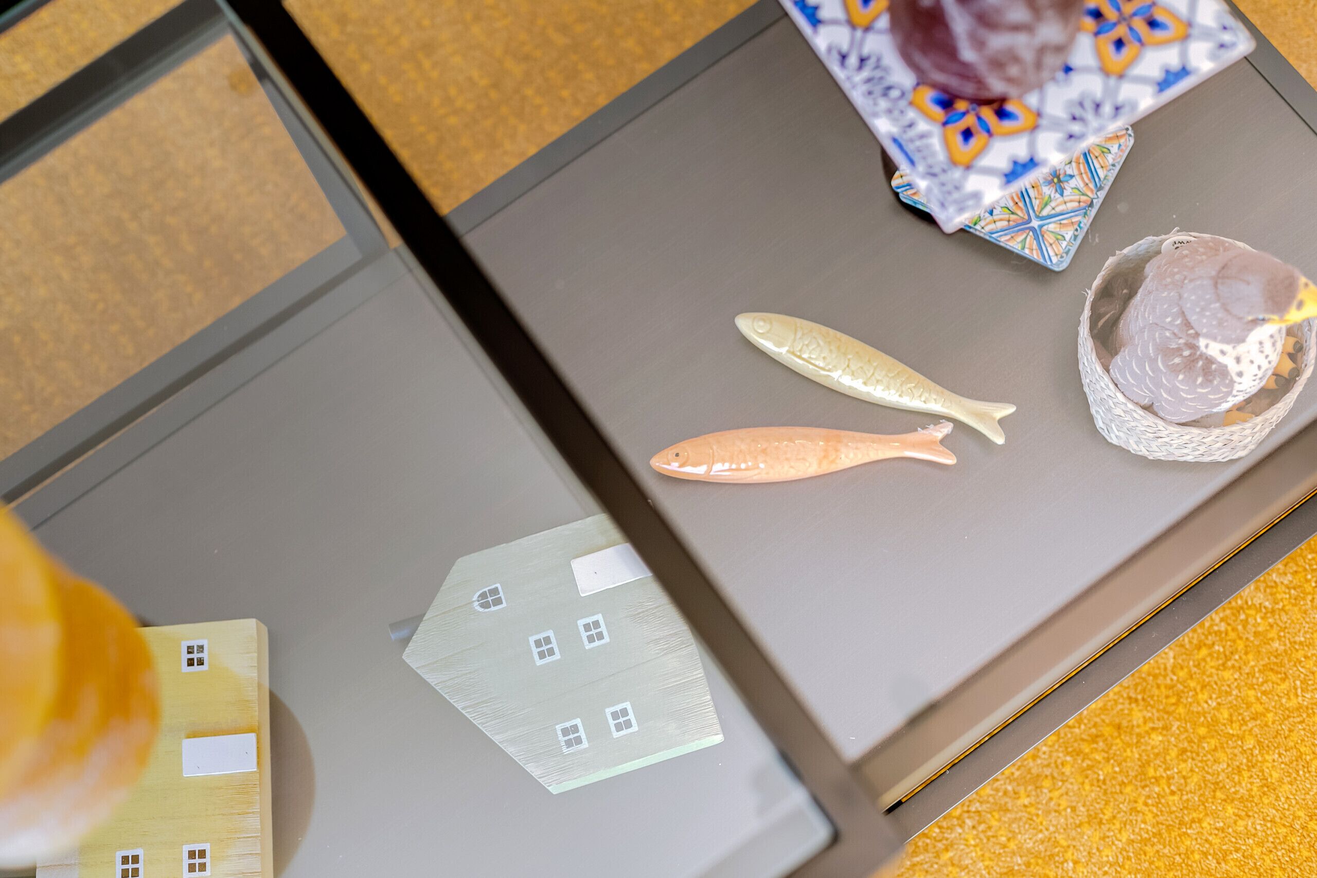 Une tablette sur laquelle est affiché un modèle de maison et deux modèles de poissons, le tout posé sur une table.