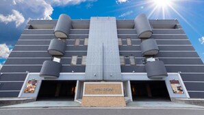 A hotel with a modern design, featuring a central glass facade and multiple cylindrical structures on the roof. - Hotel Sylph - Adults Only (Wakayama)