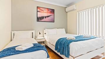 3 habitaciones, escritorio y tabla de planchar con plancha