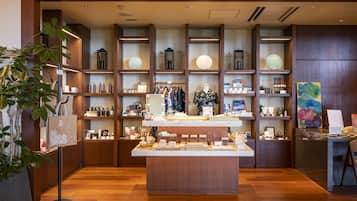 A well-organized retail space with wooden shelving, a central display table, and various products.