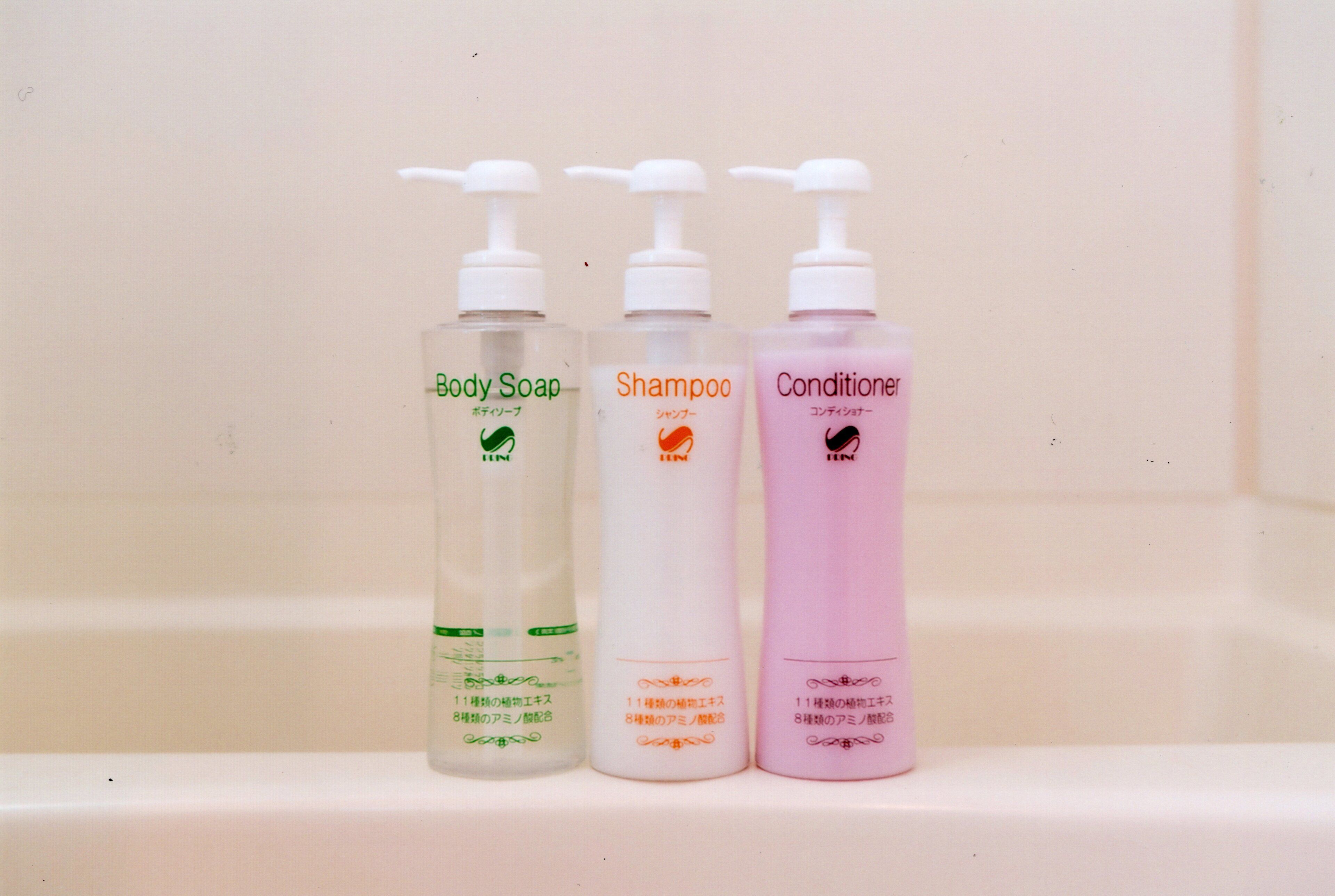 Three bottles of personal care products on a shelf.